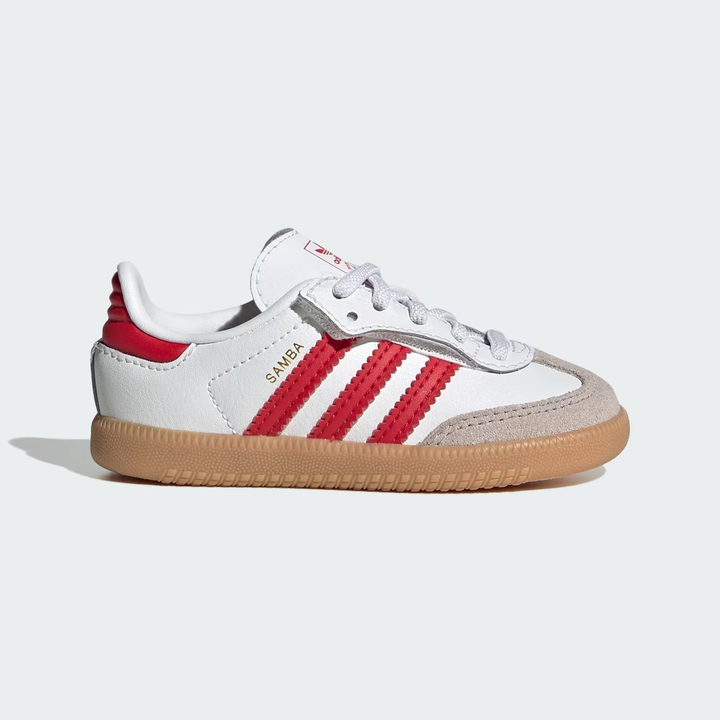 White and red sneaker with brown sole on a light gray background