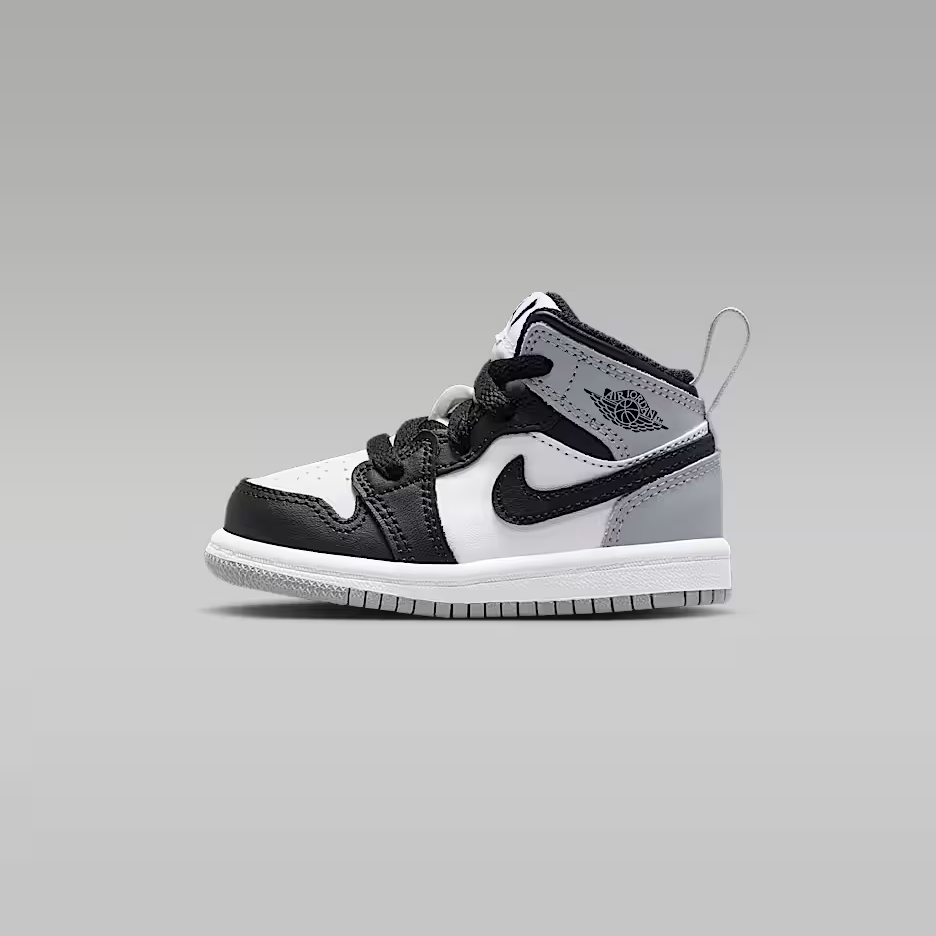 Black and white sneaker with a gray sole on a gray background