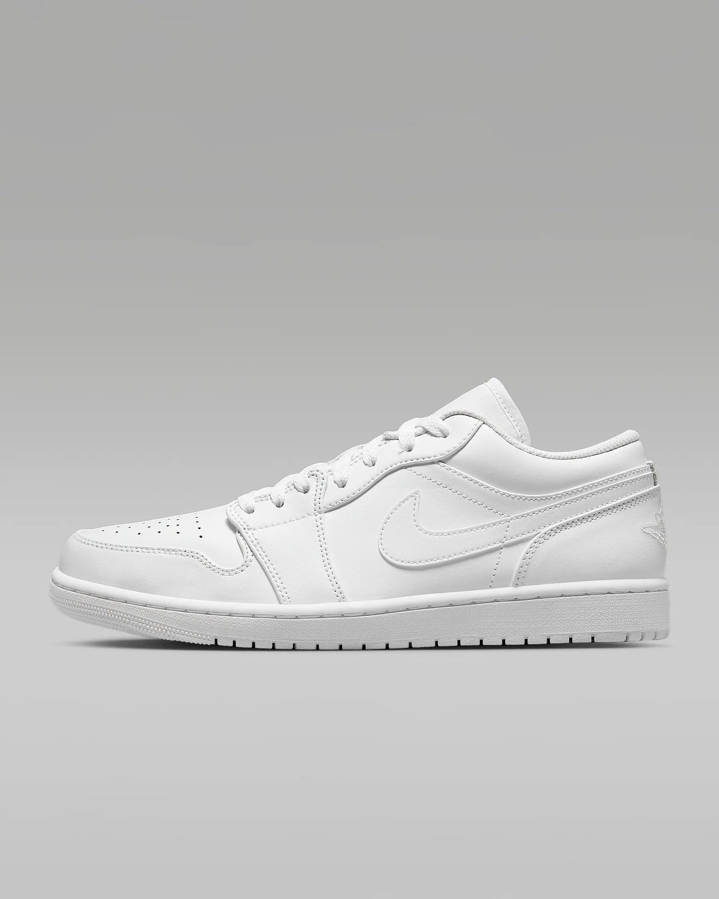 A pair of Jordan 1 Low sneakers with a white color scheme.