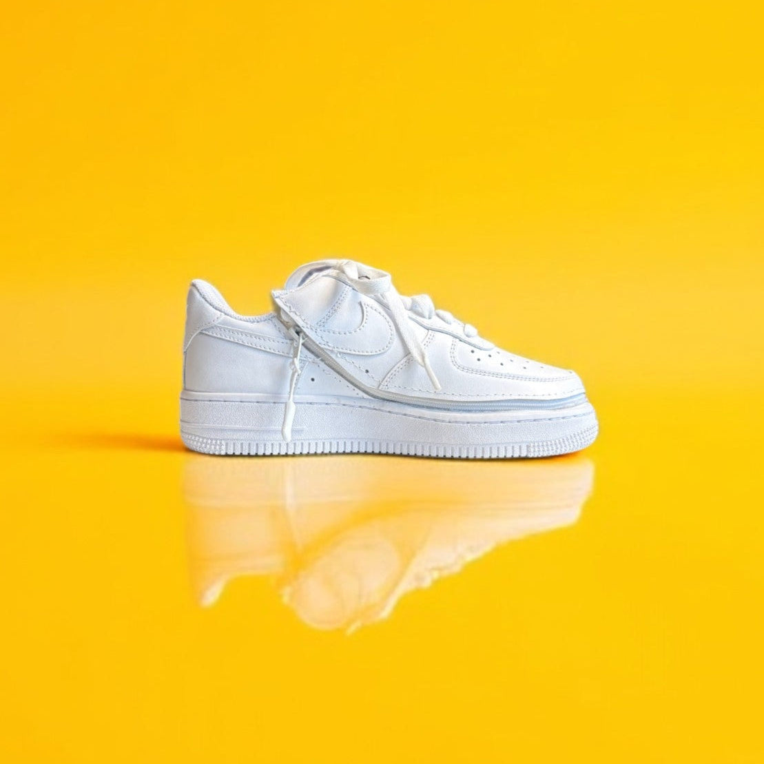 A white shoe with a zipper on a yellow background. The shoe is zipped shut