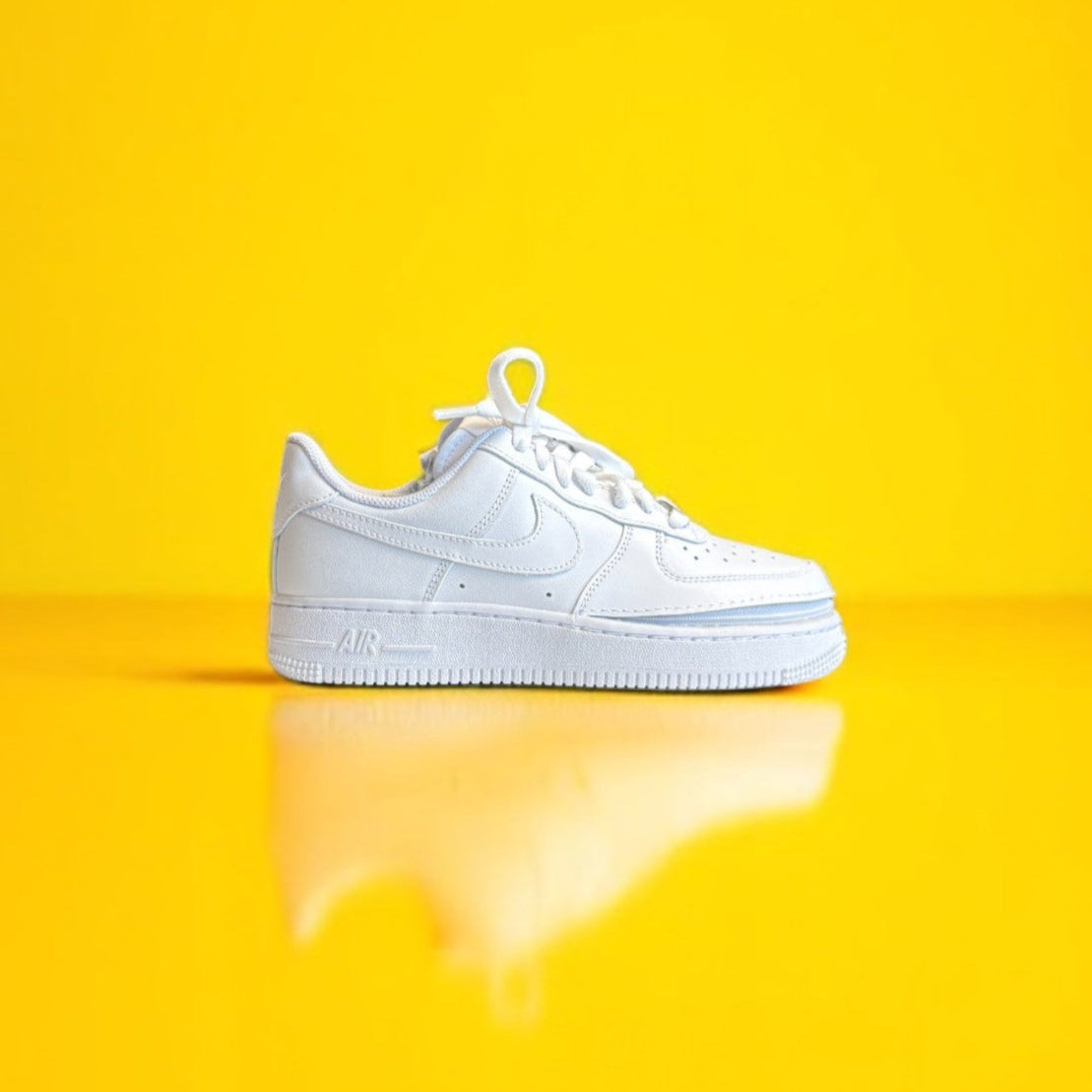 A white shoe with a zipper on a yellow background. The shoe is zipped shut