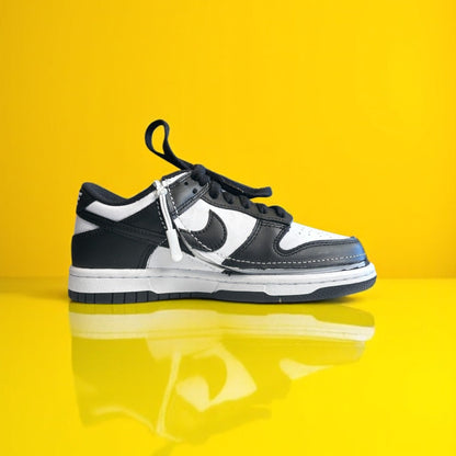 A pair of kids white and white shoes with a zipper. The shoe is zipped shut