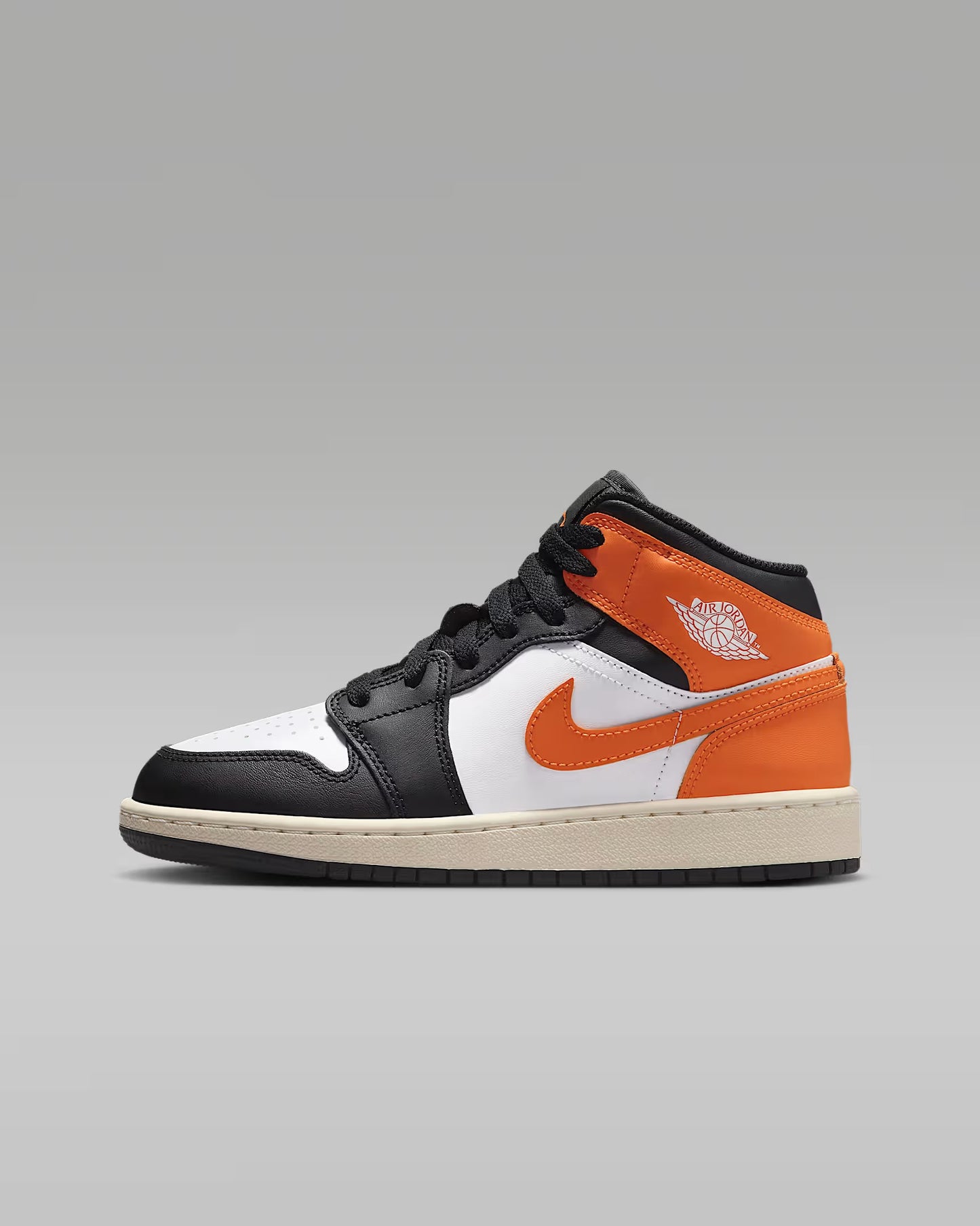 Black, orange, and white sneaker on a gray background