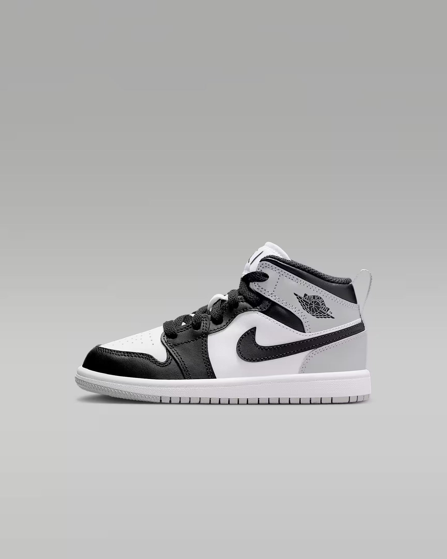 Black and white sneaker with a brand logo on a gray background