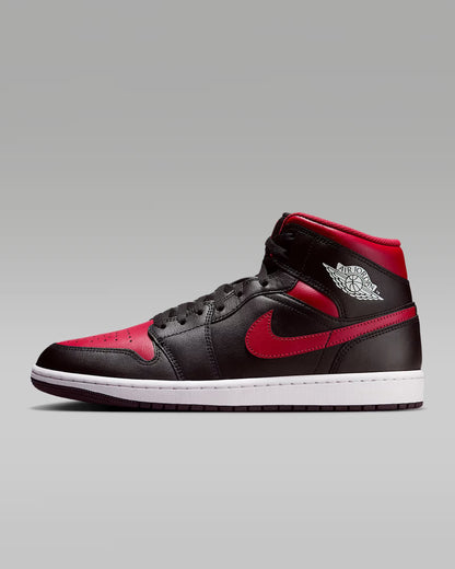 A pair of red and black Jordan 1 Mid sneakers