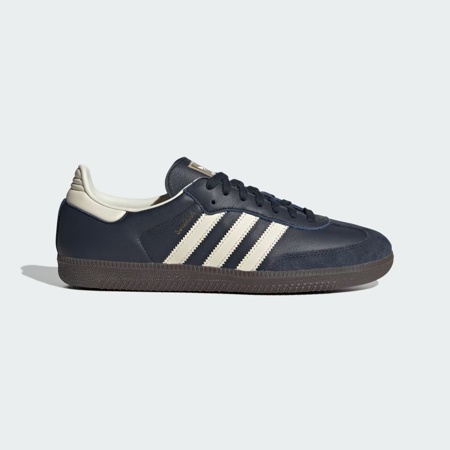 Navy blue sneaker with white stripes on a light gray background