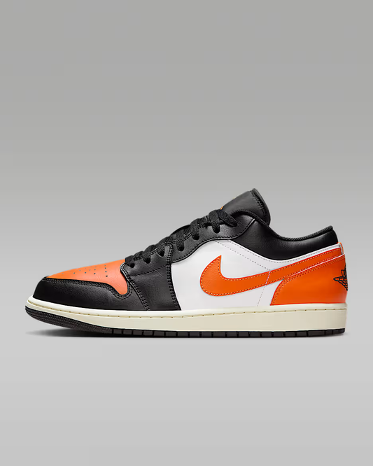 Black, orange, and white sneaker on a gray background