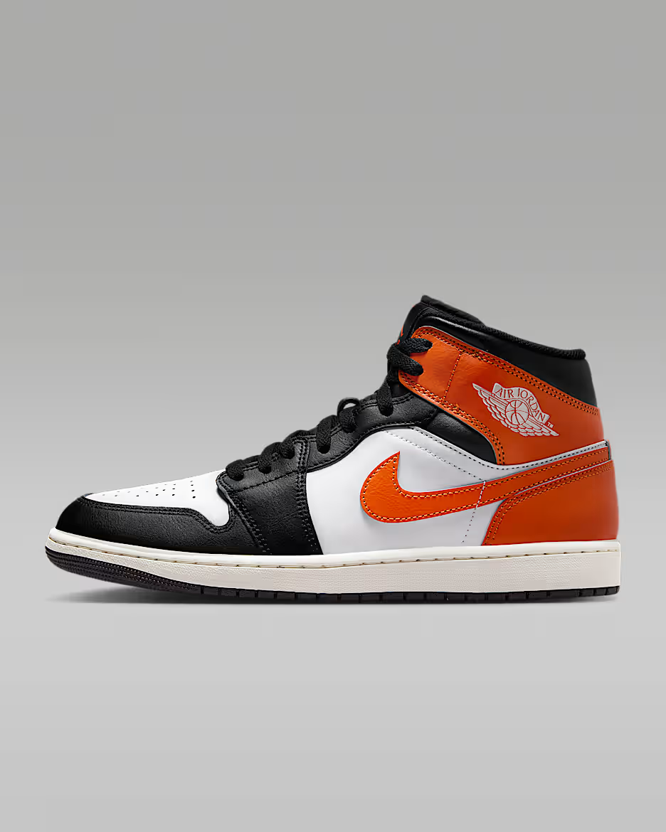 Black, orange, and white sneaker on a gray background