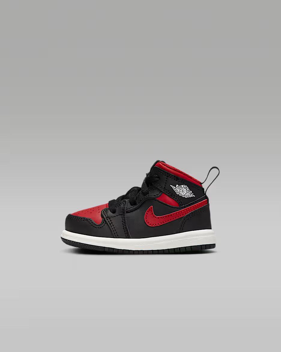 Black and red sneaker with a white logo on a gray background